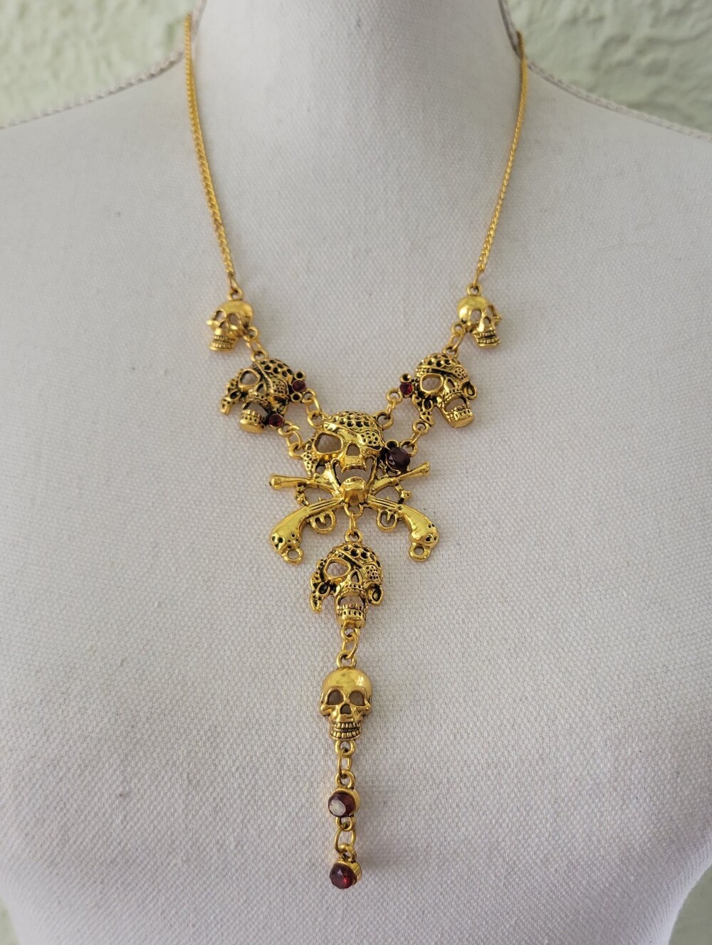 Gold skull necklace with red accents